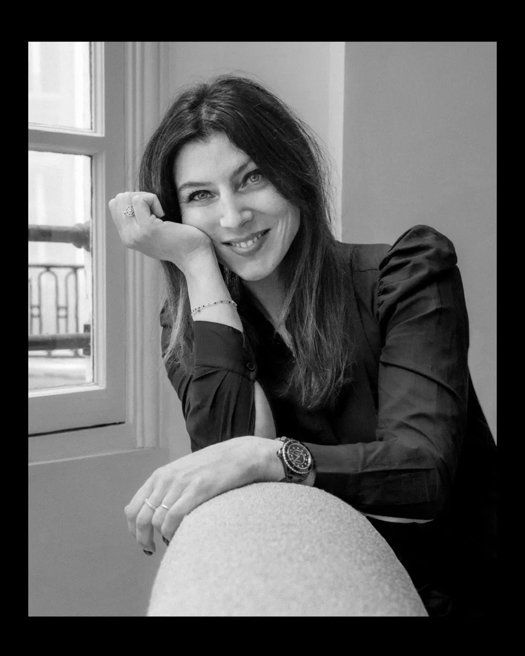 Portrait de femme accoudée à un fauteuil en noir et blanc