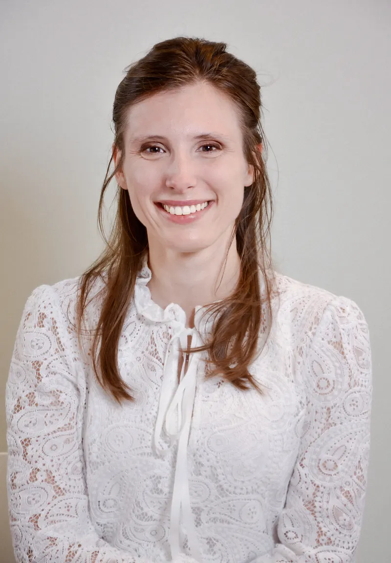 Portrait corporate d'une femme en blouse blanche sur fond clair