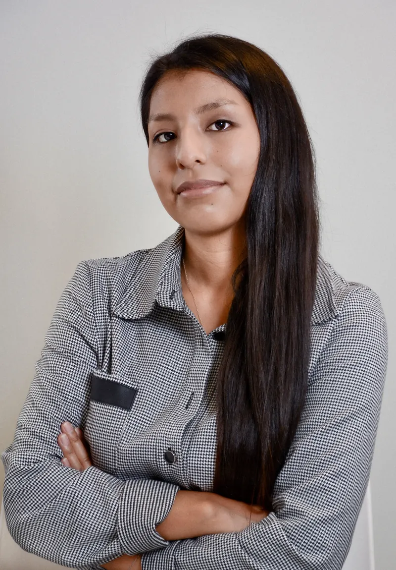 Portrait corporate d'une femme en chemise rayée, bras croisés, sur fond clair