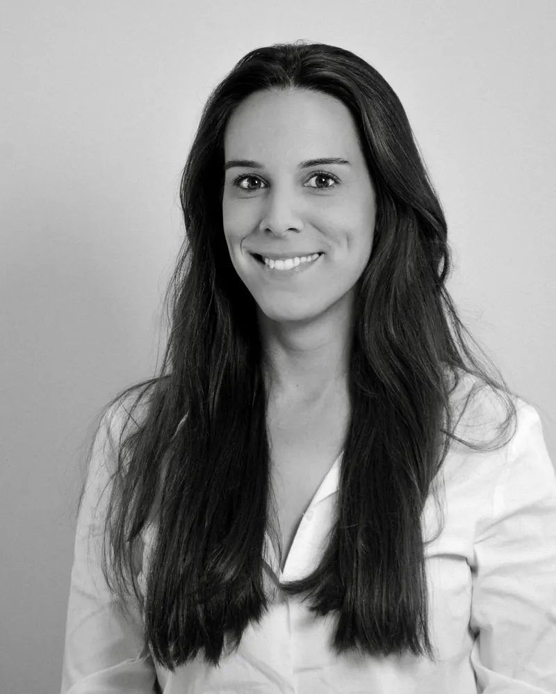 Portrait corporate en noir et blanc d'une femme en chemise blanche sur fond clair