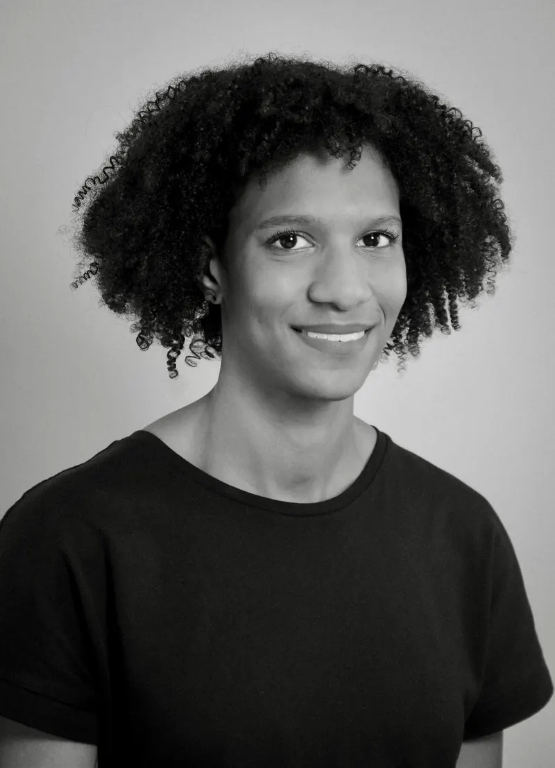 Portrait corporate en noir et blanc d'une femme aux cheveux bouclés sur fond clair