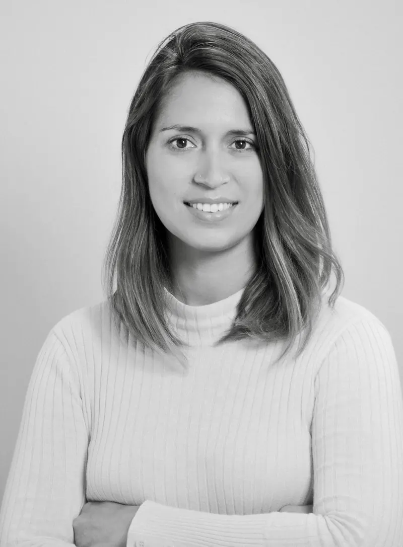 Portrait corporate en noir et blanc d'une femme en pull clair, souriante face à l'objectif