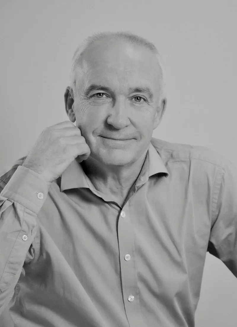 Portrait corporate en noir et blanc d'un homme senior, la main posée près du visage