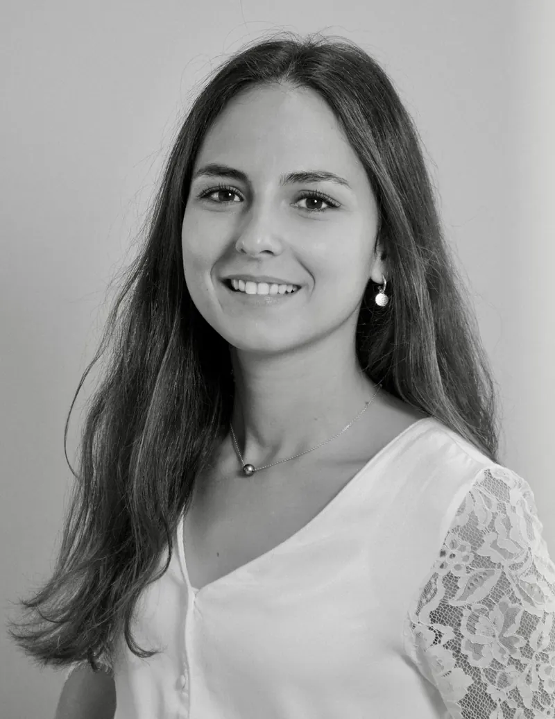 Portrait corporate en noir et blanc d'une jeune femme en blouse claire avec manche en dentelle
