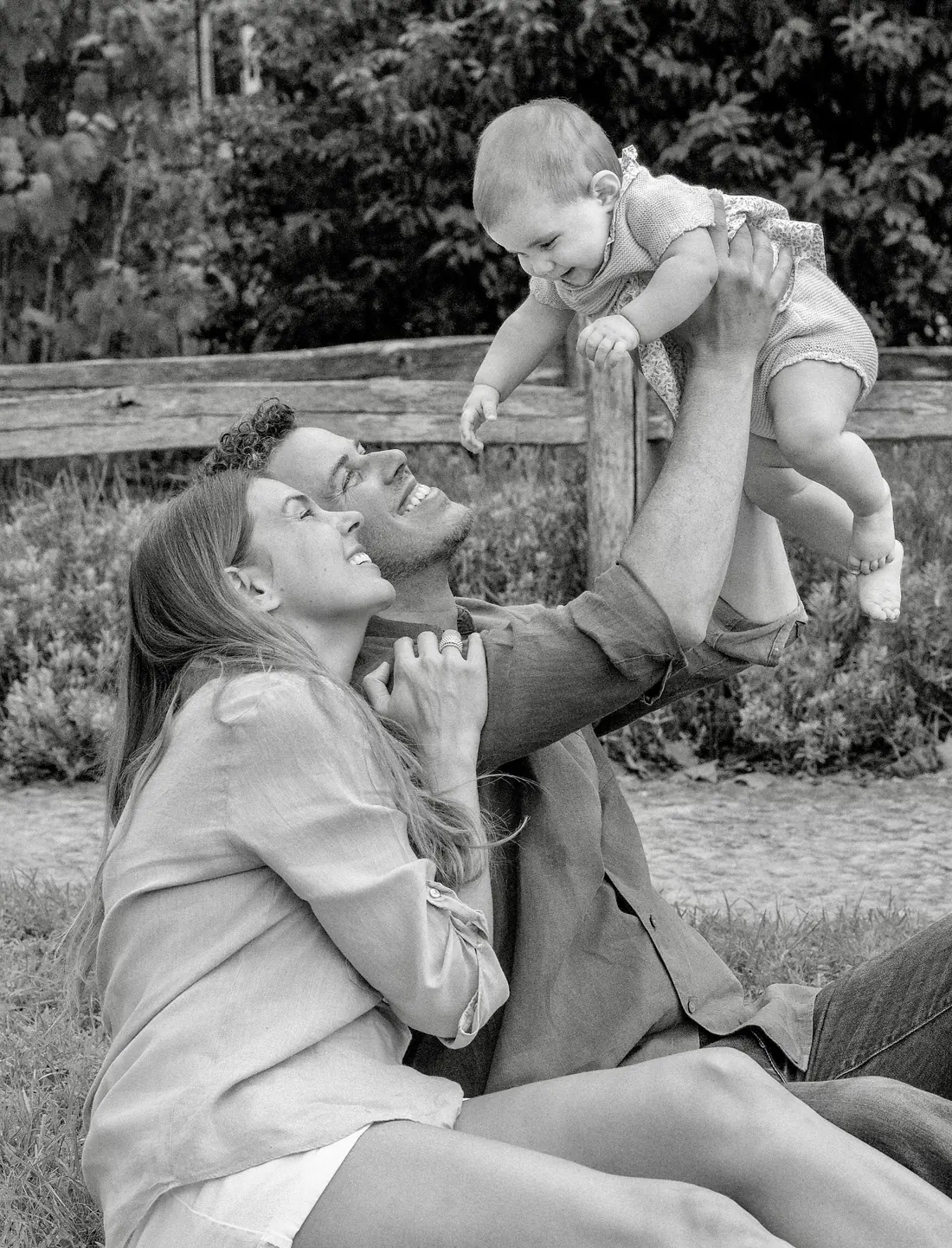 Parents souriants jouant avec leur bébé lors d’une séance photo de famille en extérieur