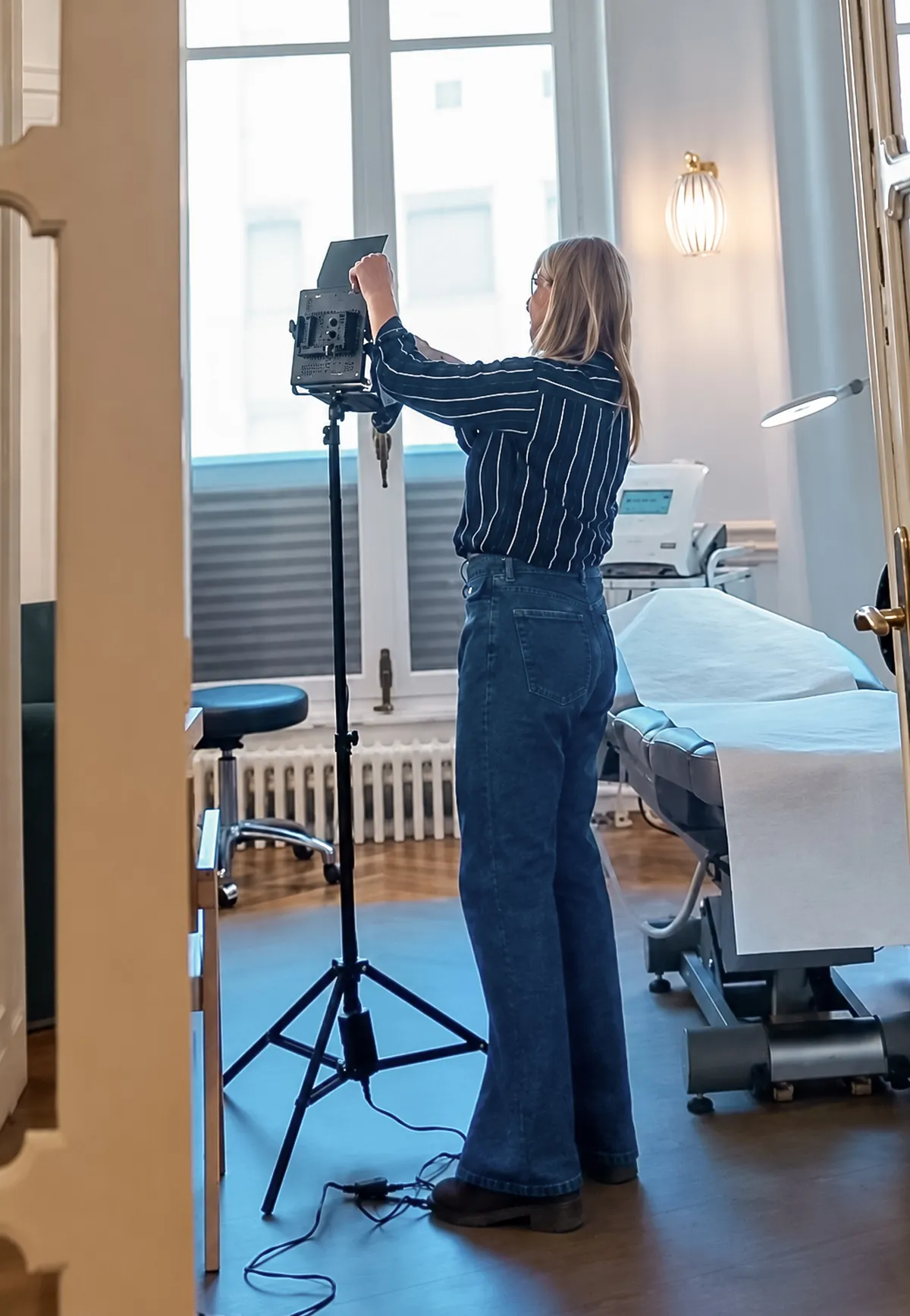 Sandrine Gluck installant un éclairage photo dans les locaux d’une entreprise