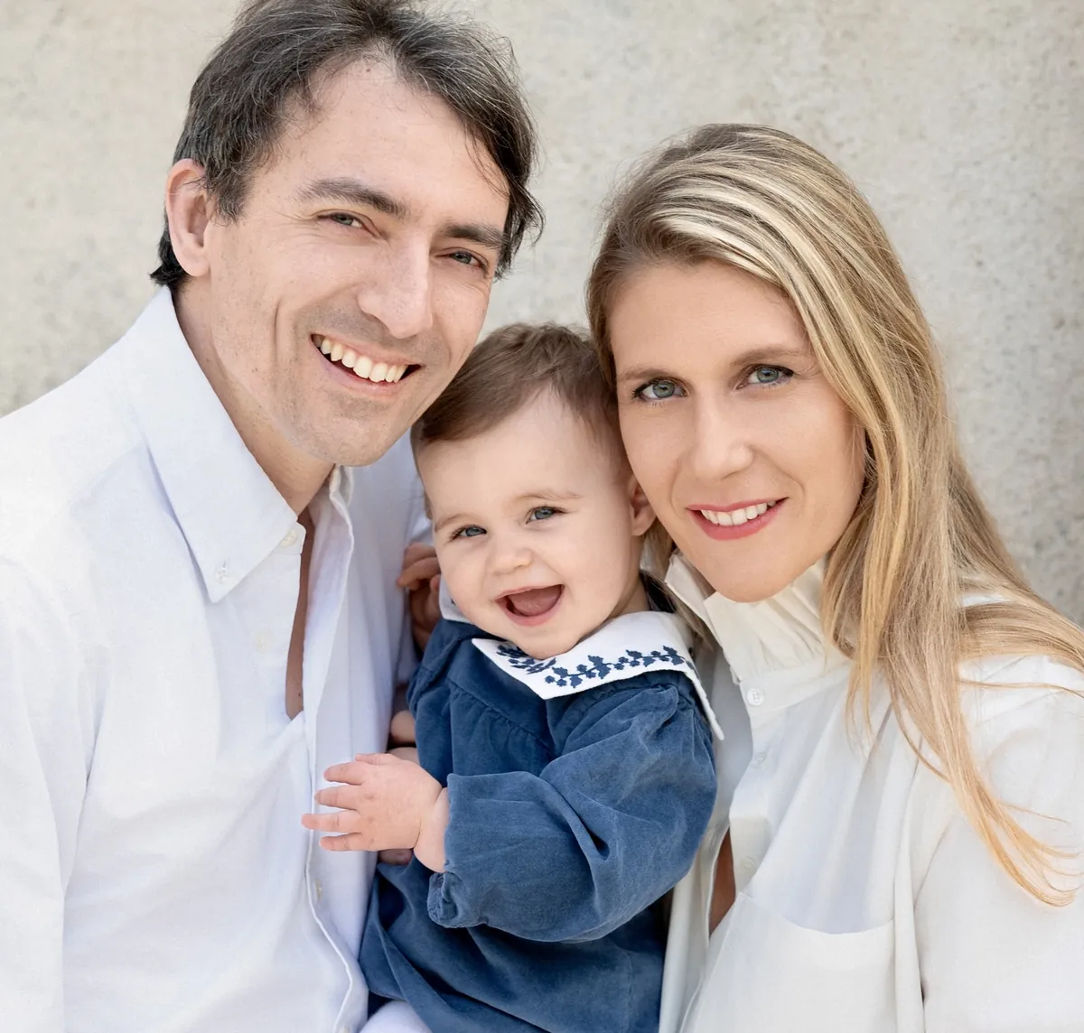 Portrait de deux parents avec leur jeune enfant face à l’objectif